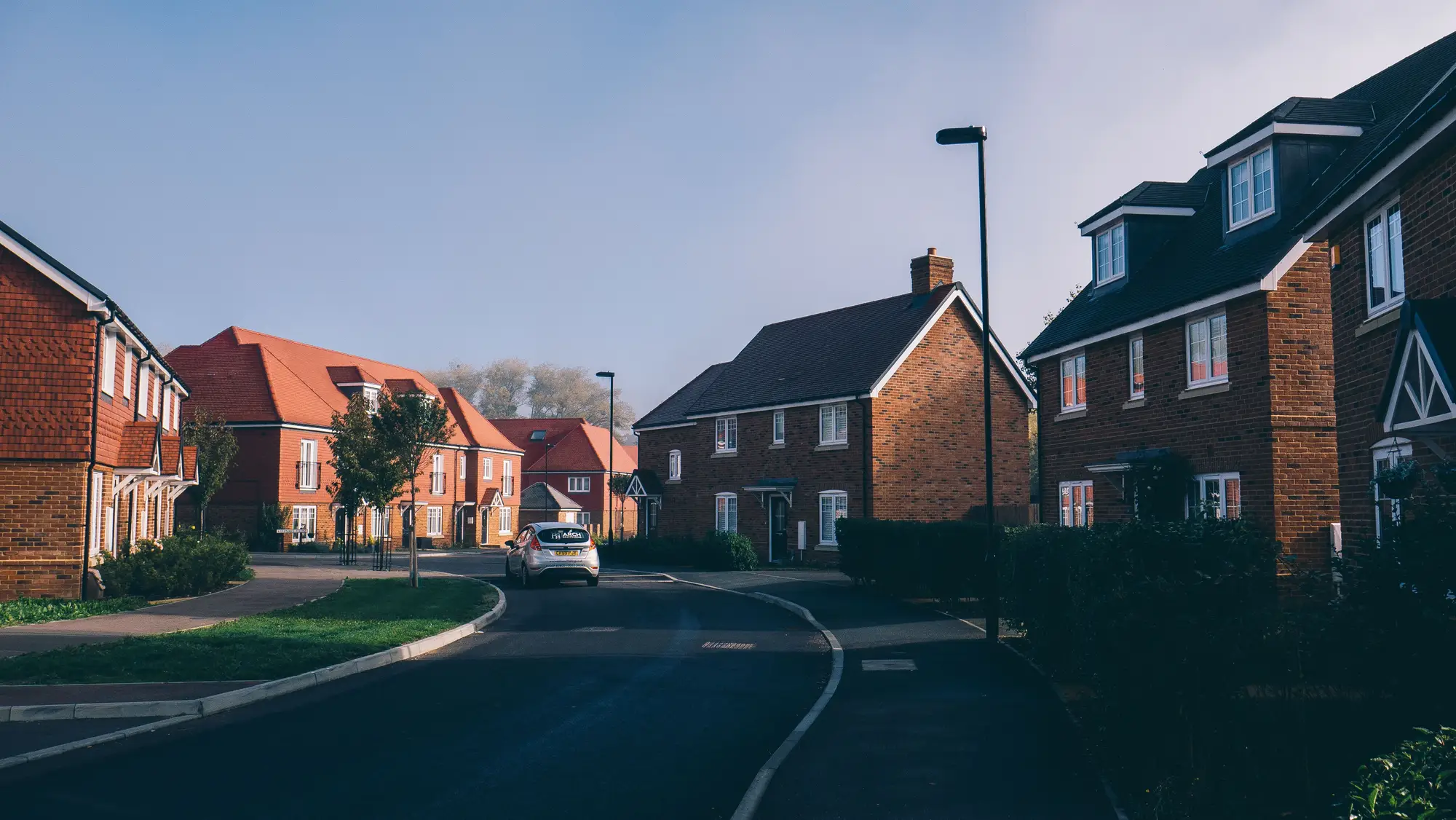 A street of brick houses on a new estate in the south of England, early morning